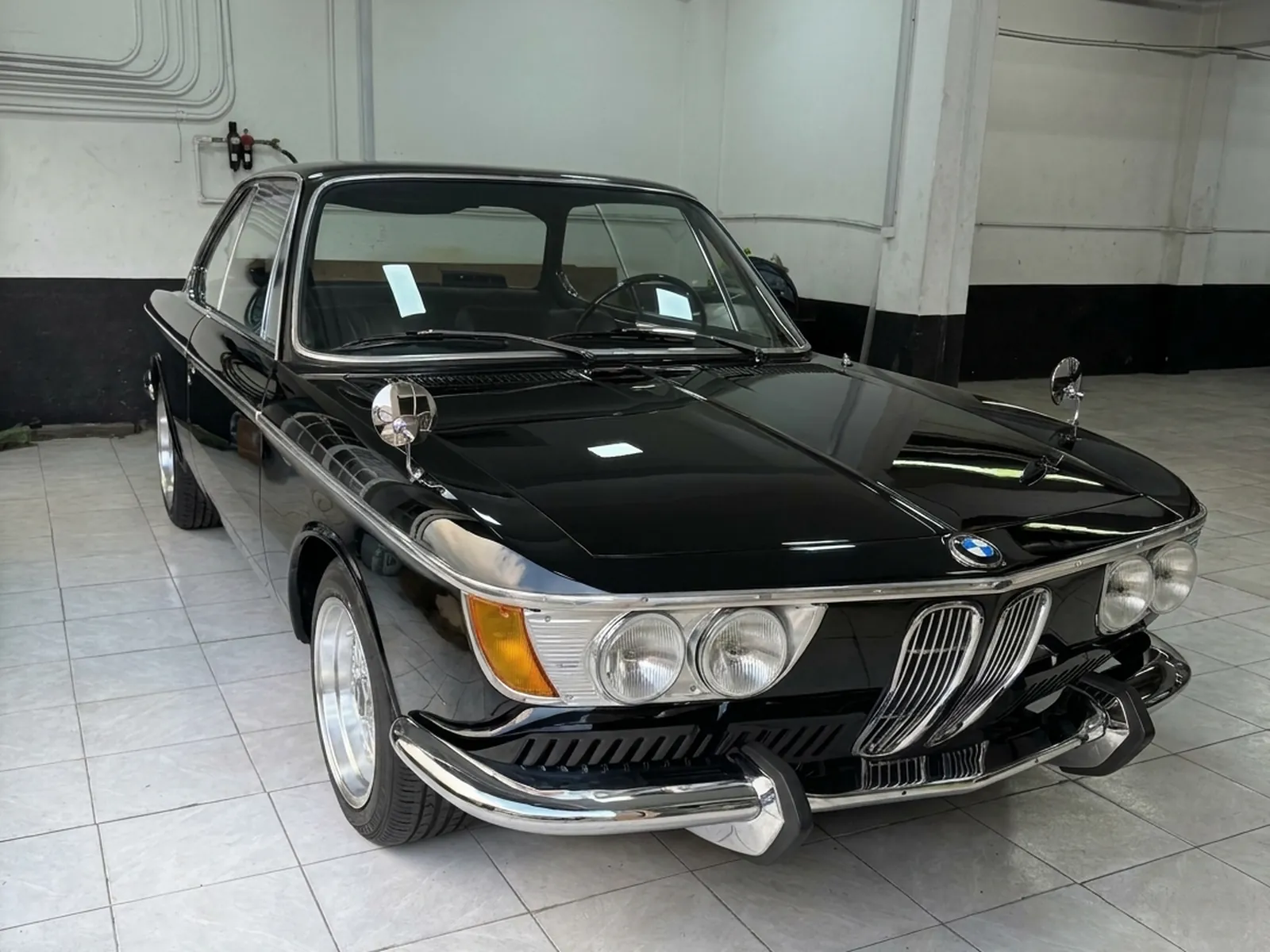 BMW 2000 CS terminado en negro, dentro del taller
